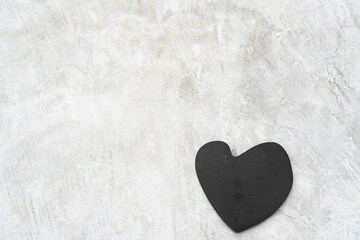 Black heart on wall background. dark heart on gray concrete wall. close-up image. empty copy space. happy Valentines day idea.