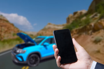 Man use mobile phone, blur image of the car is broken down as background.