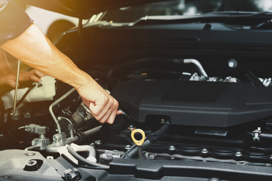 car mechanic image and on-site car repair services Image of a mechanic holding a wrench repairing a car