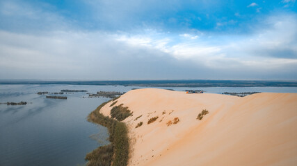 A sand dune with lake in background. An image from Yellow Lake, Saudi Arabia.