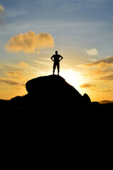 Silhouetted Man on a Mountain at Sunrise