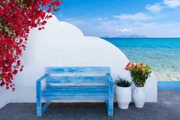 Fototapeten the colors of Greece with a bench in front of a wall and a view to the beautiful mediterranean sea © Wilm Ihlenfeld