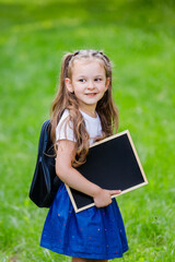 Back to school. Portrait of schoolgirl with backpack and drawing board.