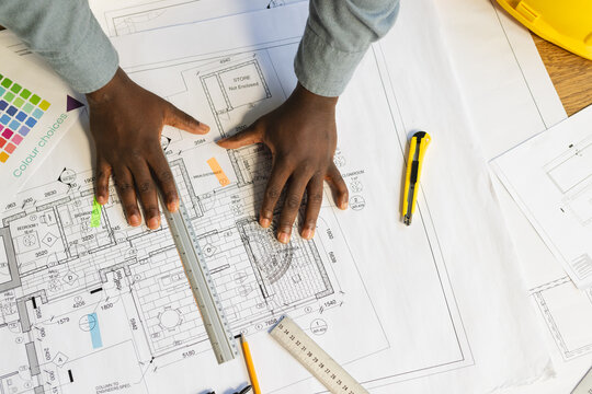 African american casual businessman with hands on building project in office