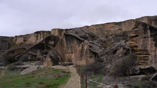 Pan across rock bluff landscape of prehistoric Gobustan rock art site