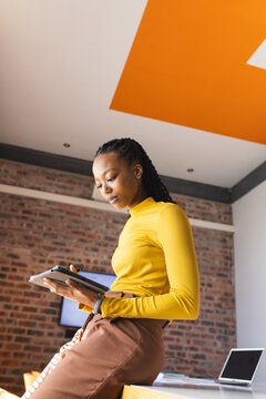 African american casual businesswoman using tablet in office