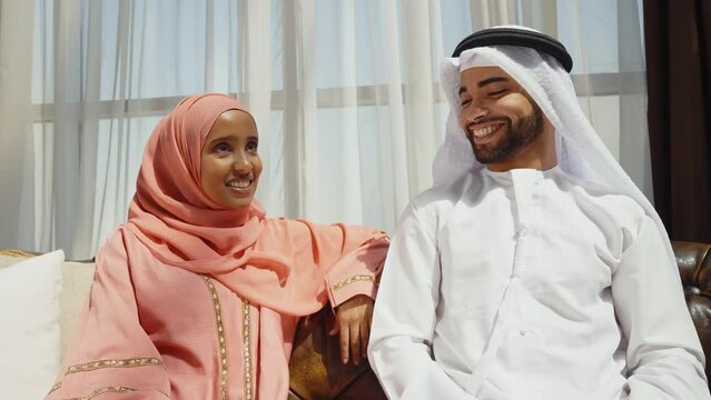 Happy couple wearing traditional clothes from the emirates spending time in their beautiful apartment in Dubai