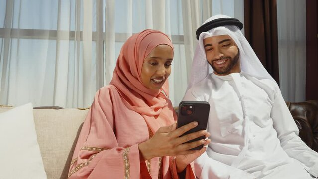 Happy couple wearing traditional clothes from the emirates spending time in their beautiful apartment in Dubai