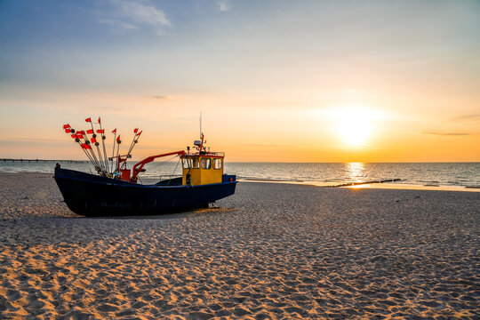 Sunset on the beach on the Polish Baltic Sea. Fishing boat in the evening near Międzyzdroje, Poland.
