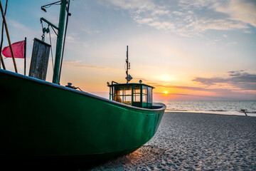 Sunset on the beach on the Polish Baltic Sea. Fishing boat in the evening near Międzyzdroje, Poland.
