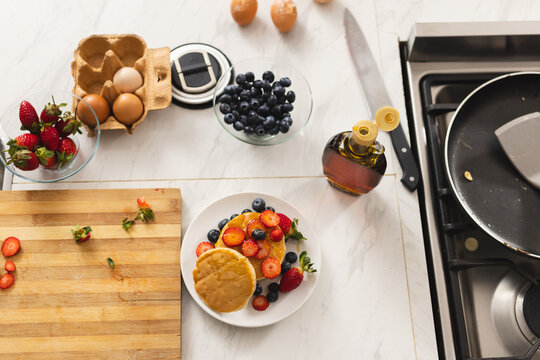 Close up of pancakes with fruits on countertop in kitchen at home