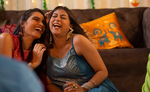 Portrait Of Two Young Women Laughing At Home During Diwali Celebrating