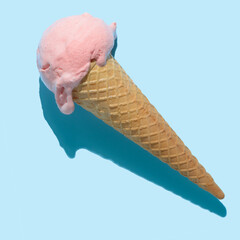 top view of pink ice cream cone with hard shadow isolated on blue, minimal summer concept