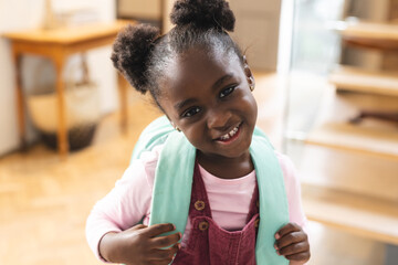 Portrait of happy african american girl wearing backpack