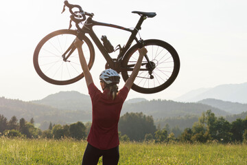Young female professional bicyclist during road cycling sprint, continual motion with maximal effort, close-up view.