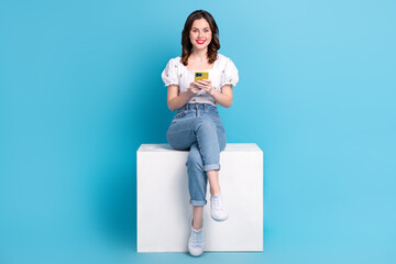 Full length photo of cute adorable lady wear white blouse texting modern gadget isolated blue color background