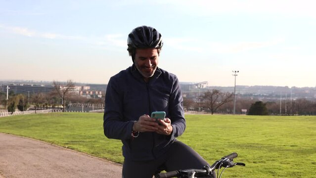 mature man with bicycle doing sport takes photo with smart phone