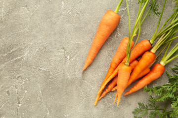 Bunch of baby carrots on grey concrete background. Space for text