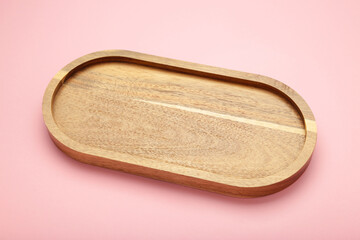 Empty wooden tray on pink background. Rectangular wooden dish