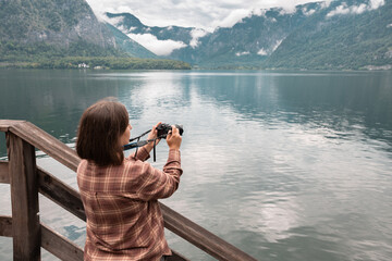  Tourist in a plaid shirt takes a picture of a lake with a reflection, an outdoor recreation...