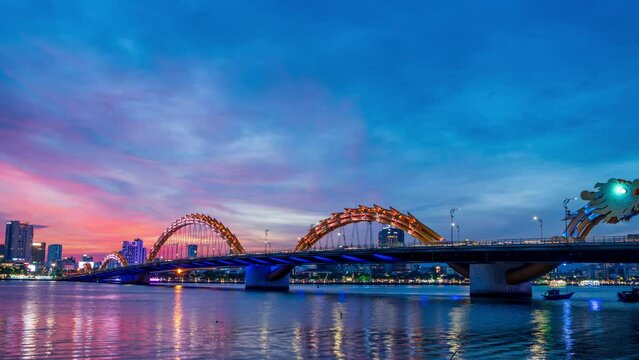 Zoom out, Day to night  Time-lapse of Dragon Bridge and traffic in Da Nang Vietnam