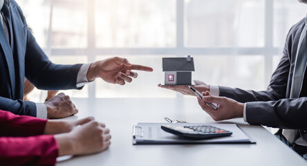 Modern office meet realtor young couple sitting at desk discuss new house plan first home