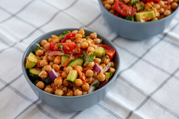 Homemade Avocado Chickpea Salad with Chili Lime Dressing in Bowls, side view. .