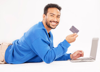 Online shopping, laptop and portrait man smile for credit card discount, fintech service or ecommerce sale. Studio customer, savings transfer payment or relax person banking on white background floor