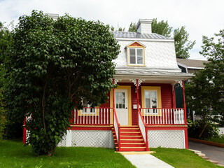 Pretty petite ancestral neoclassical red house with metal sheet roof in the Beauport area, Quebec...