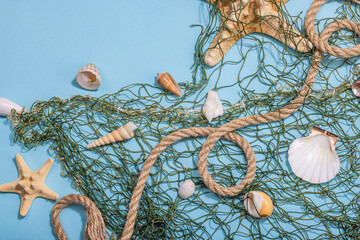 Blue nautical background with sea shells, starfishes and fishing net. Assorted marine animals