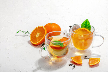 Orange tea in glass cups with ripe fruits. Refreshment seasonal drink, conceptual background