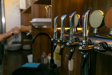 Chromed taps for draft beer in a modern bar.