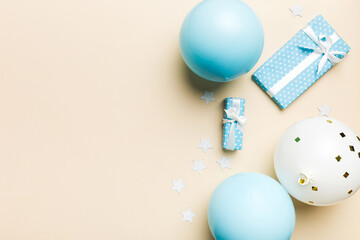 Holiday background with colorful balloon, gift and confetti. Flat lay style. Birthday or party greeting card with copy space