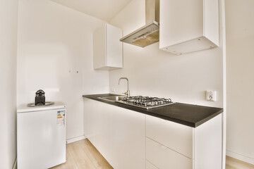a kitchen area with white cabinets and black counter tops on the counters in this apartment is very well equipped for entertaining