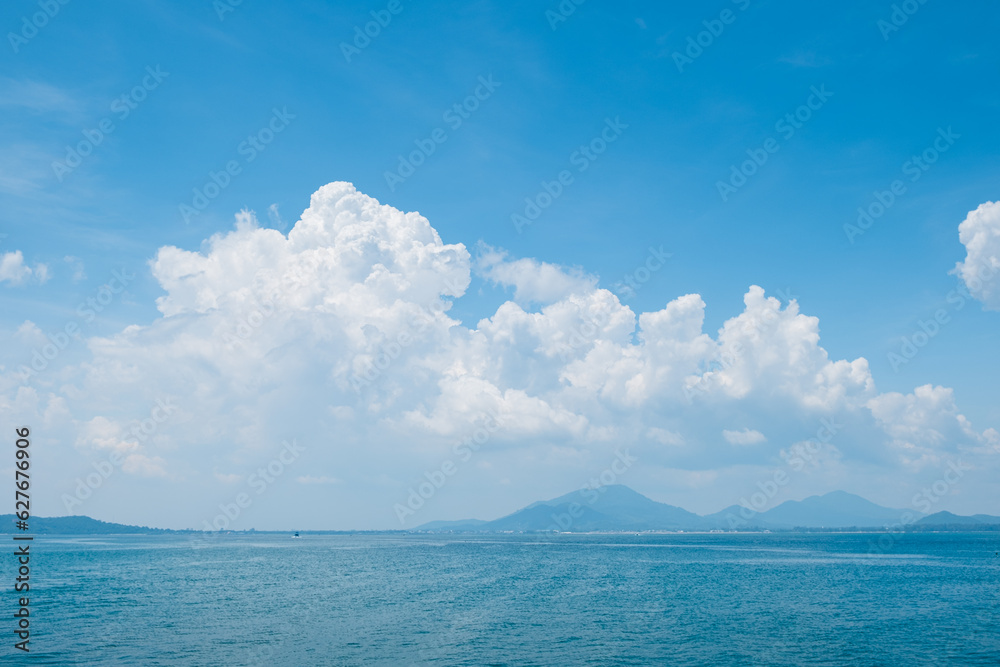 Wall mural white cloud and blue sky over the ocean . island view from the sea . summer tropical landscape .