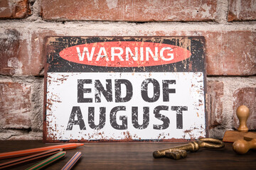 END OF AUGUST. Warning sign on wooden office desk