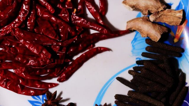 Indian spices in serving plate table top spin close up.