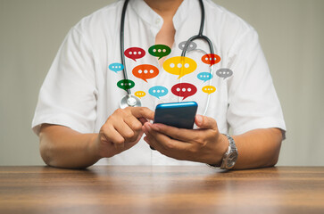 Physician using a smartphone with colorful chat icons on application digital web and social media while sitting at the table
