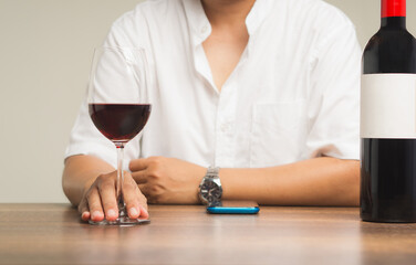 Businessman holding a glass of red wine while sitting at the table.