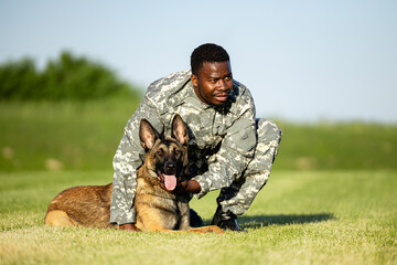 Soldier in uniform standing by his military dog.