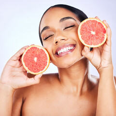 Woman, health and grapefruit for natural beauty, skincare or cosmetics on a studio background. Face of female person with citrus fruit for healthy nutrition, vitamin C or diet and healthcare wellness