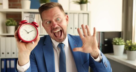 Crazy smiling businessman holding alarm clock and waving hand 4k movie. Time management concept