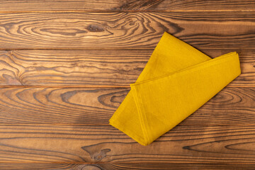 Kitchen towel on a brown wooden background. Kitchen utensils and textile napkin. A stack of cotton...