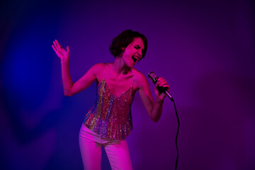 Photo of excited rock pop singer lady singing mic crazy songs on event occasion isolated neon...