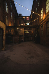 Dark street in an industrial area illuminated by small lanterns
