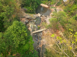 The Mo Pang Waterfall in Pai, Thailand, surrounded by rocks and trees from a bird's eye view taken with the drone.