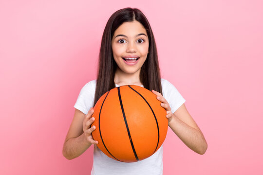 Photo portrait of cute schoolgirl excited shocked basketball match support dressed stylish white clothes isolated on pink color background
