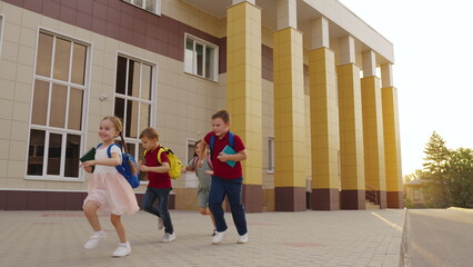 children enjoying childhood by running laughing together. attending school learning important lessons teamwork. carry backpacks have fun group, creating memories schoolyard. running children with