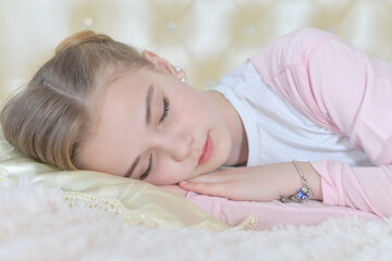 Girl sleeps on a white pillow.
