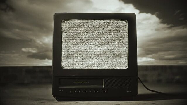 Retro Television Static Noise Interference TV Vintage Technology Old Film. Old black and white television with static noise interference outdoors. Zoom in